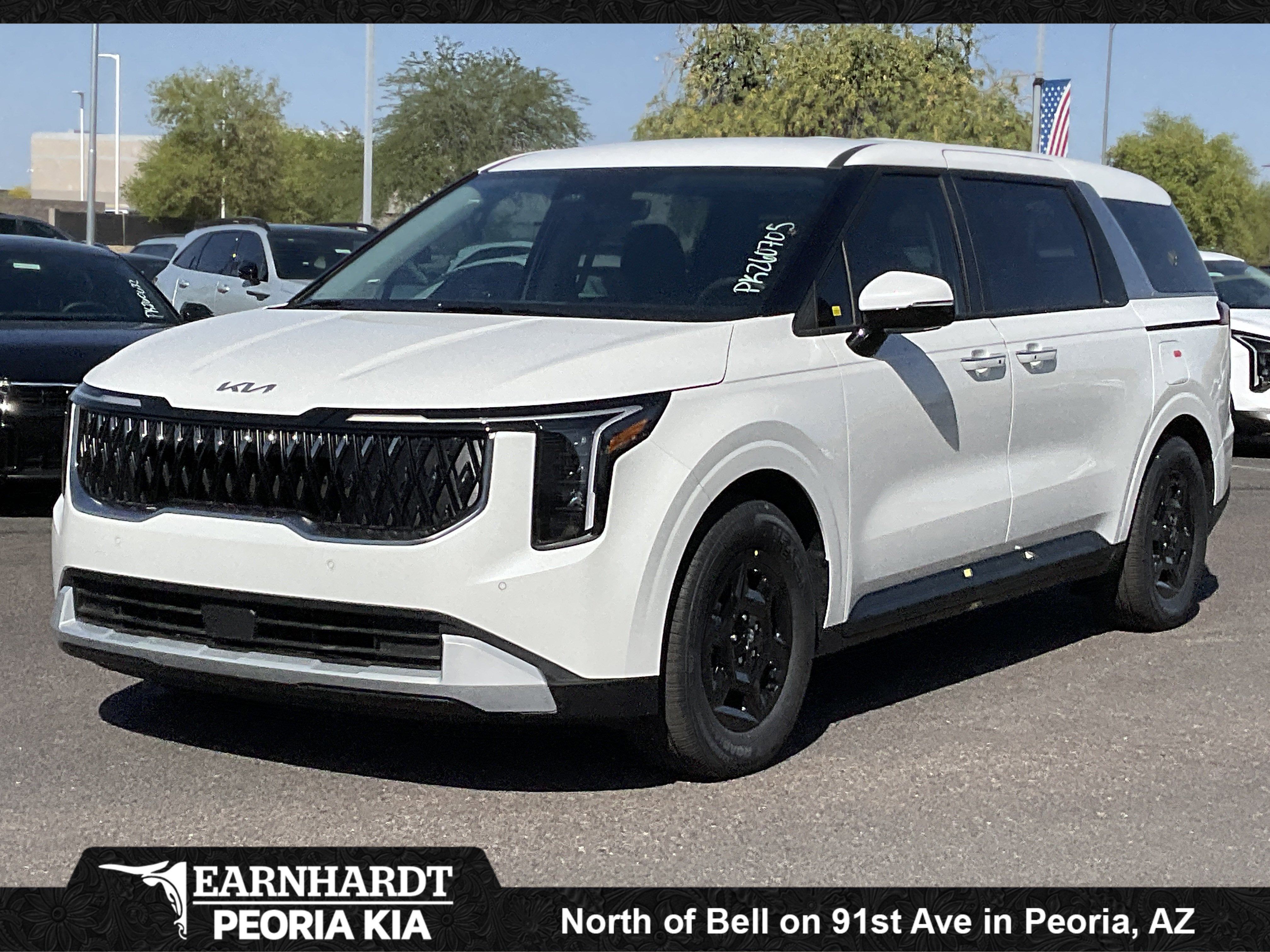 2026 Kia Carnival LXS in Snow White Pearl — front three-quarter view